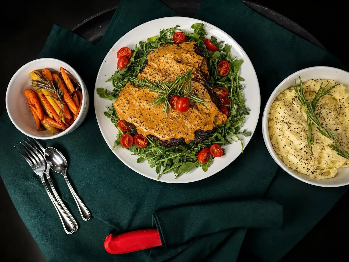 A crusted pork chop plated with seasonal garnish
